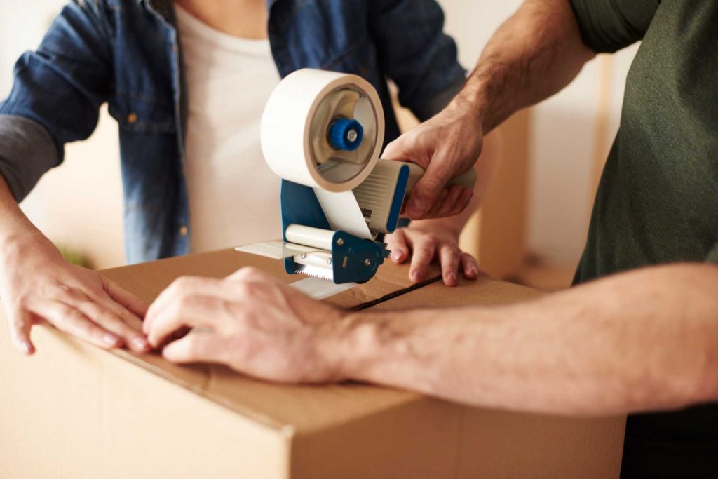 Person packing items into a moving box