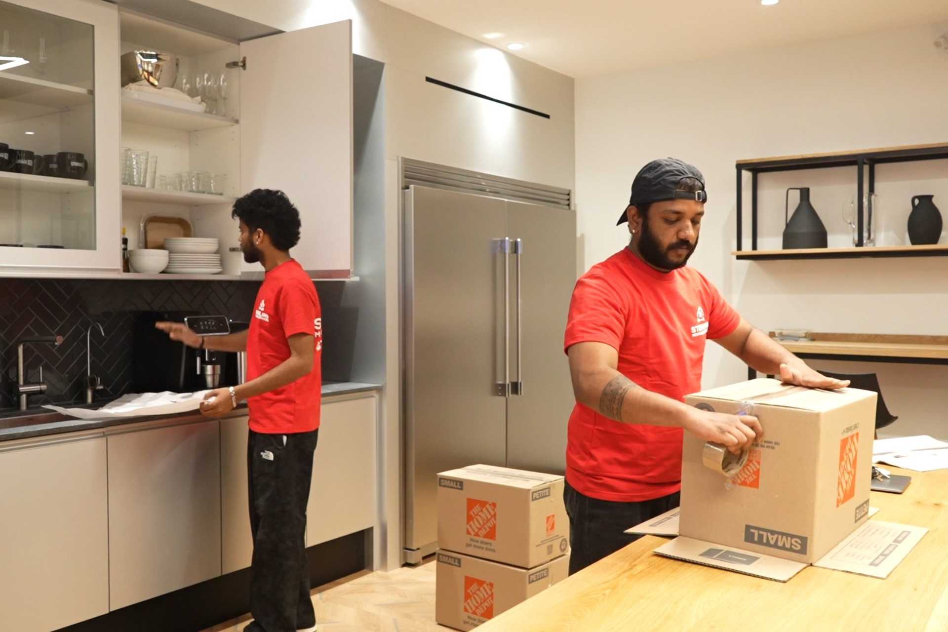 Mover packing boxes in a kitchen