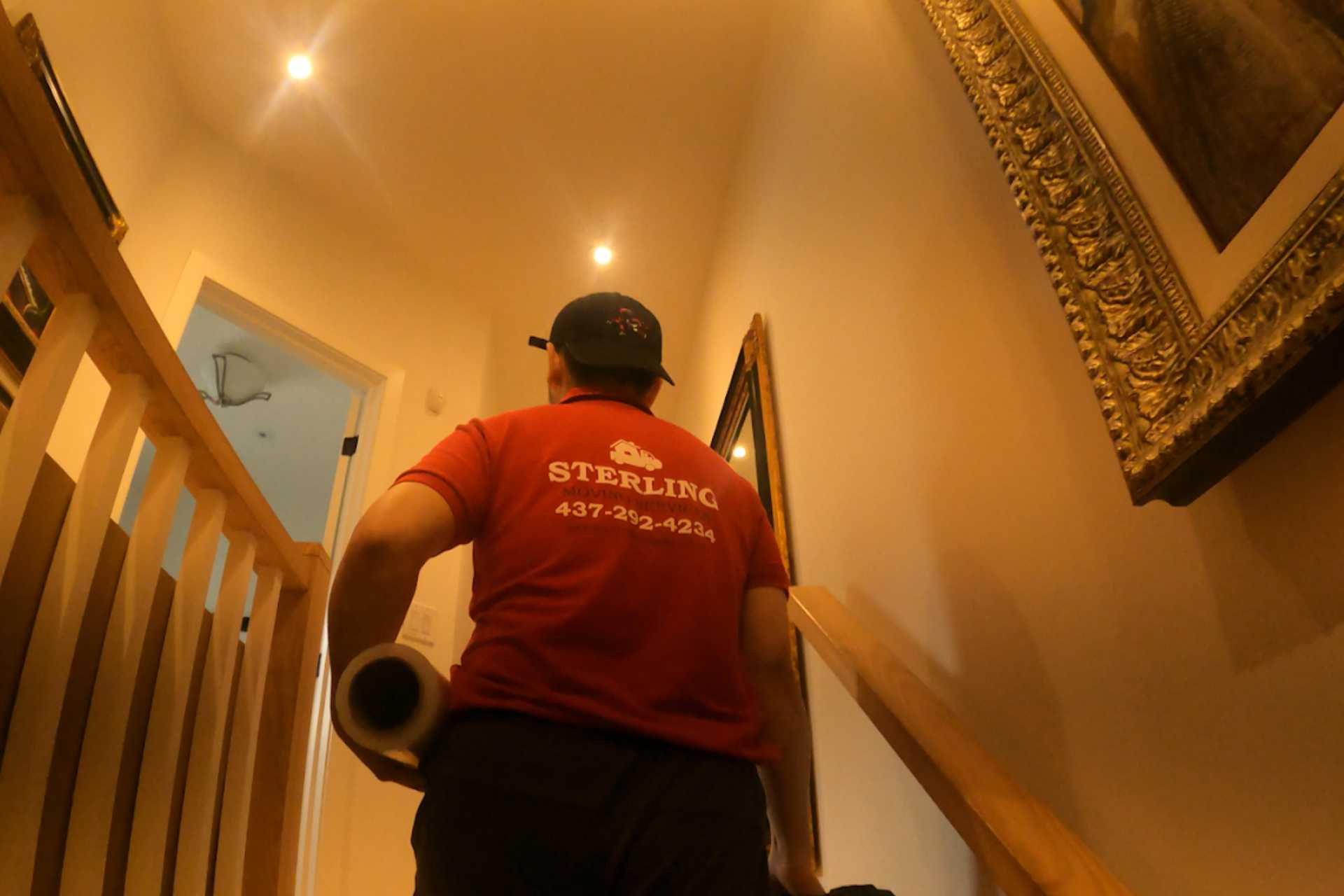 Mover carrying items up residential stairs